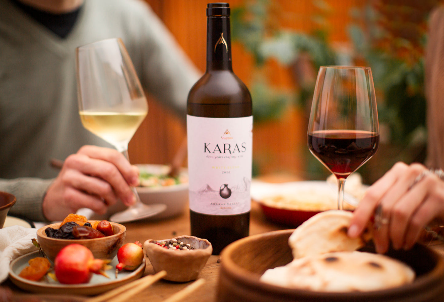 Karas White Blend served with red and white wine at a shared meal.