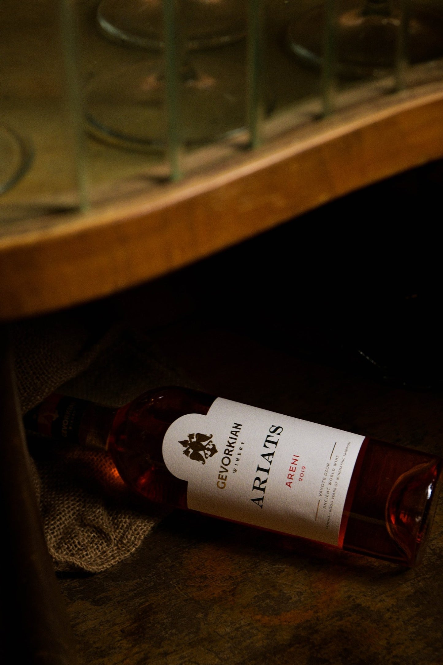 Gevorkian Ariats Areni 2019 rosé wine bottle under a bar shelf with glassware above