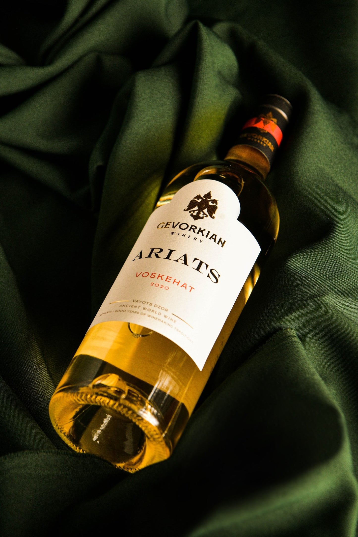Close-up of Gevorkian Ariats Voskehat 2020 white wine bottle on elegant green fabric