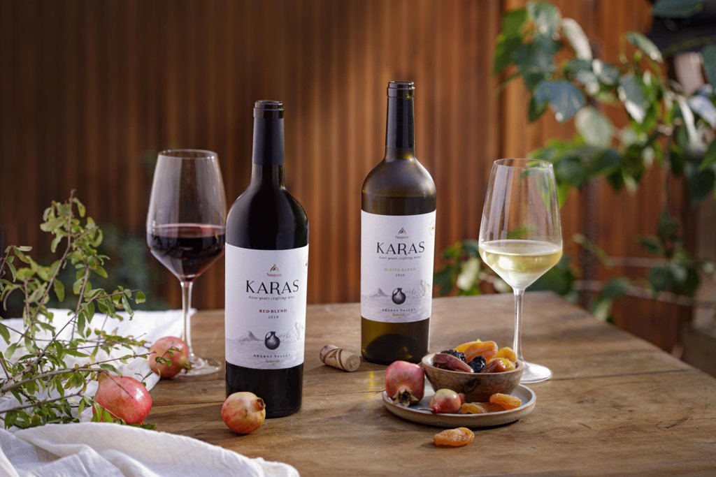 Karas Red and White Blend bottles with wine glasses and dried fruits.