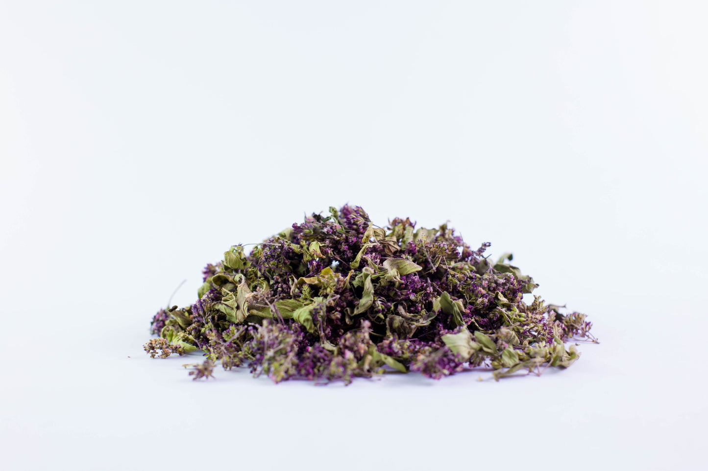 Close-up of dried organic oregano tea leaves on white background