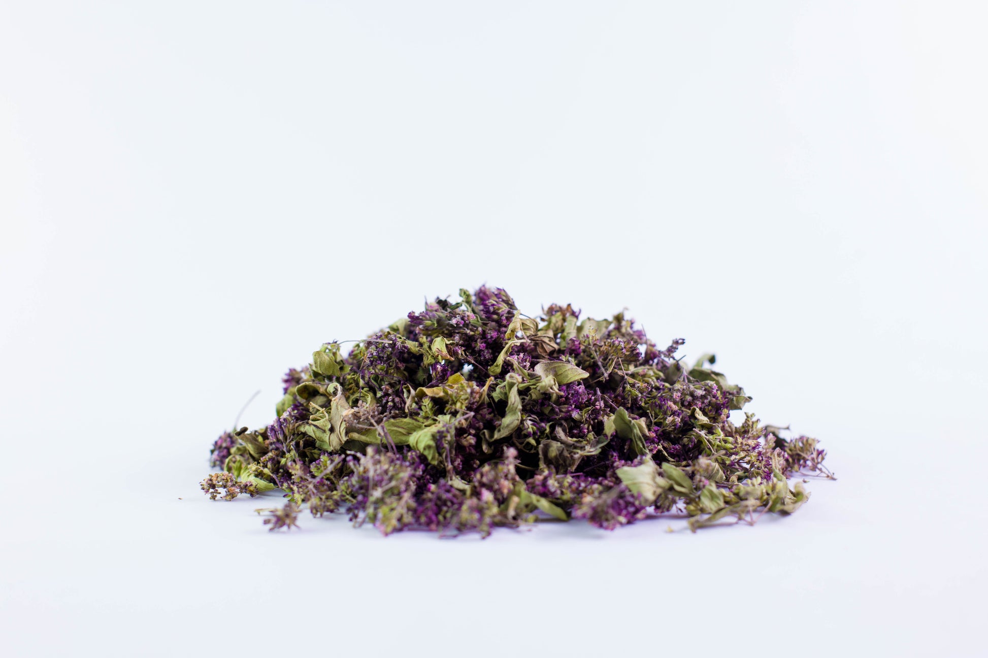 Close-up of dried organic oregano tea leaves on white background