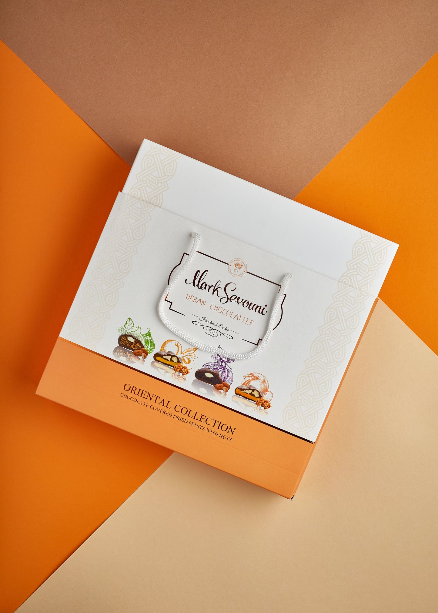Mark Sevouni Urban Chocolatier Oriental Collection gift bag displayed on a vibrant geometric background of orange and beige tones, showcasing illustrated chocolate-covered dried fruits with nuts.