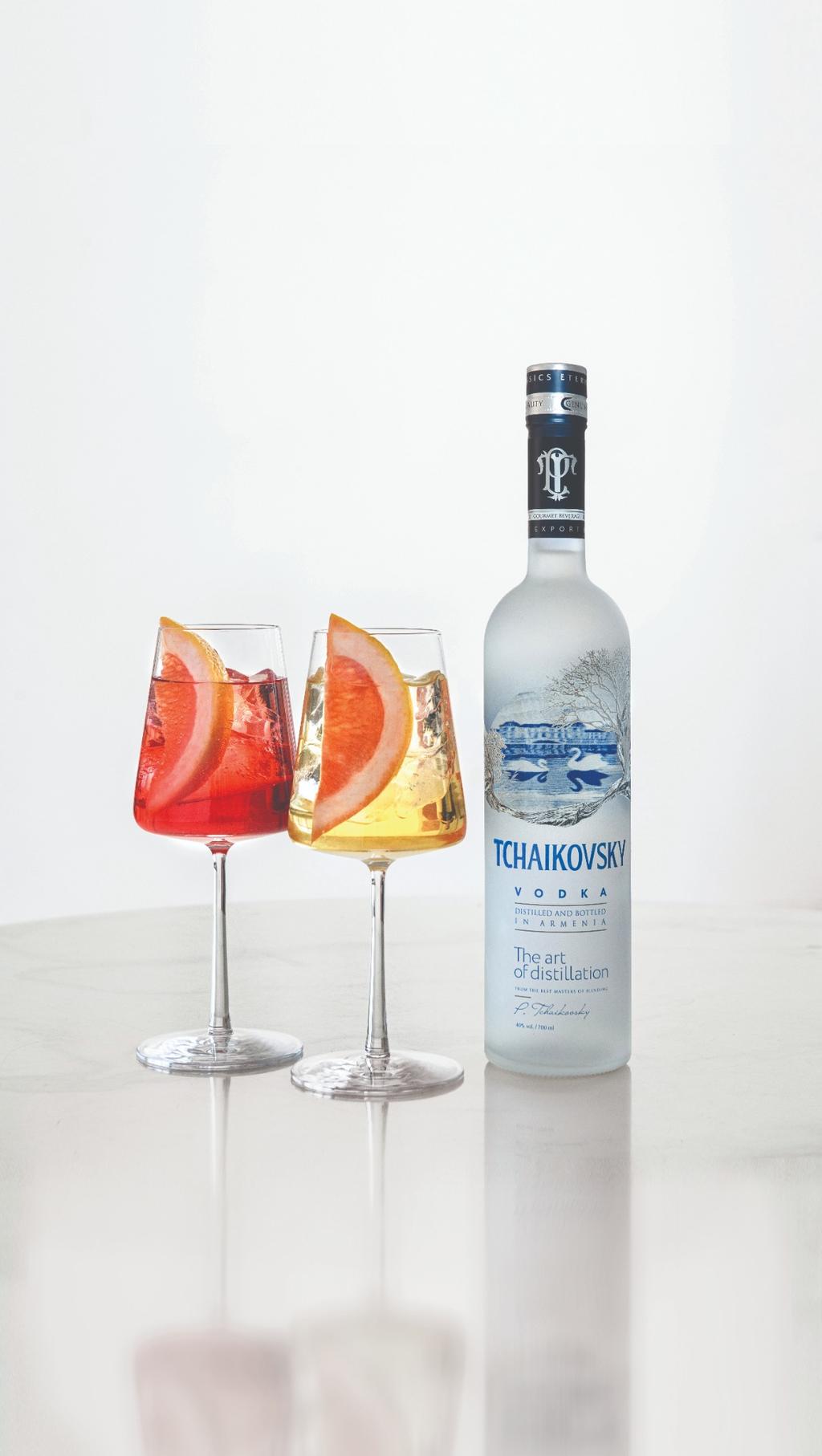 Tchaikovsky Vodka with two citrus-garnished cocktails on a white table, capturing a vibrant and refreshing moment.