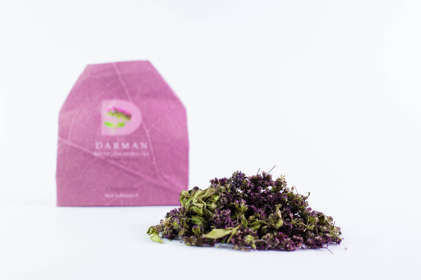 Darman organic oregano herbal tea with dried leaves in front of pink packaging