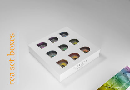 Outer sleeve removed to reveal a clean white box with nine leaf-shaped windows displaying assorted tea bags inside.
