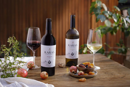 Karas Red and White Blend bottles with wine glasses and dried fruits.