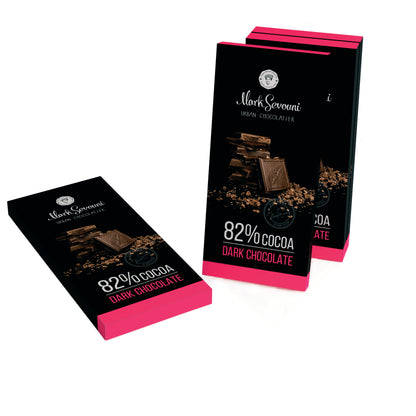 Render of three Mark Sevouni Urban Chocolatier 82% Cocoa Dark Chocolate bars, one lying flat and two upright. The sleek black and magenta packaging highlights the intensity of this premium dark chocolate.