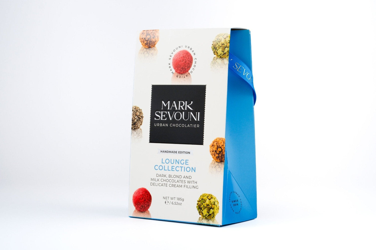 Mark Sevouni Lounge Collection box with assorted handmade chocolates in blue and white packaging featuring cream-filled truffles.
