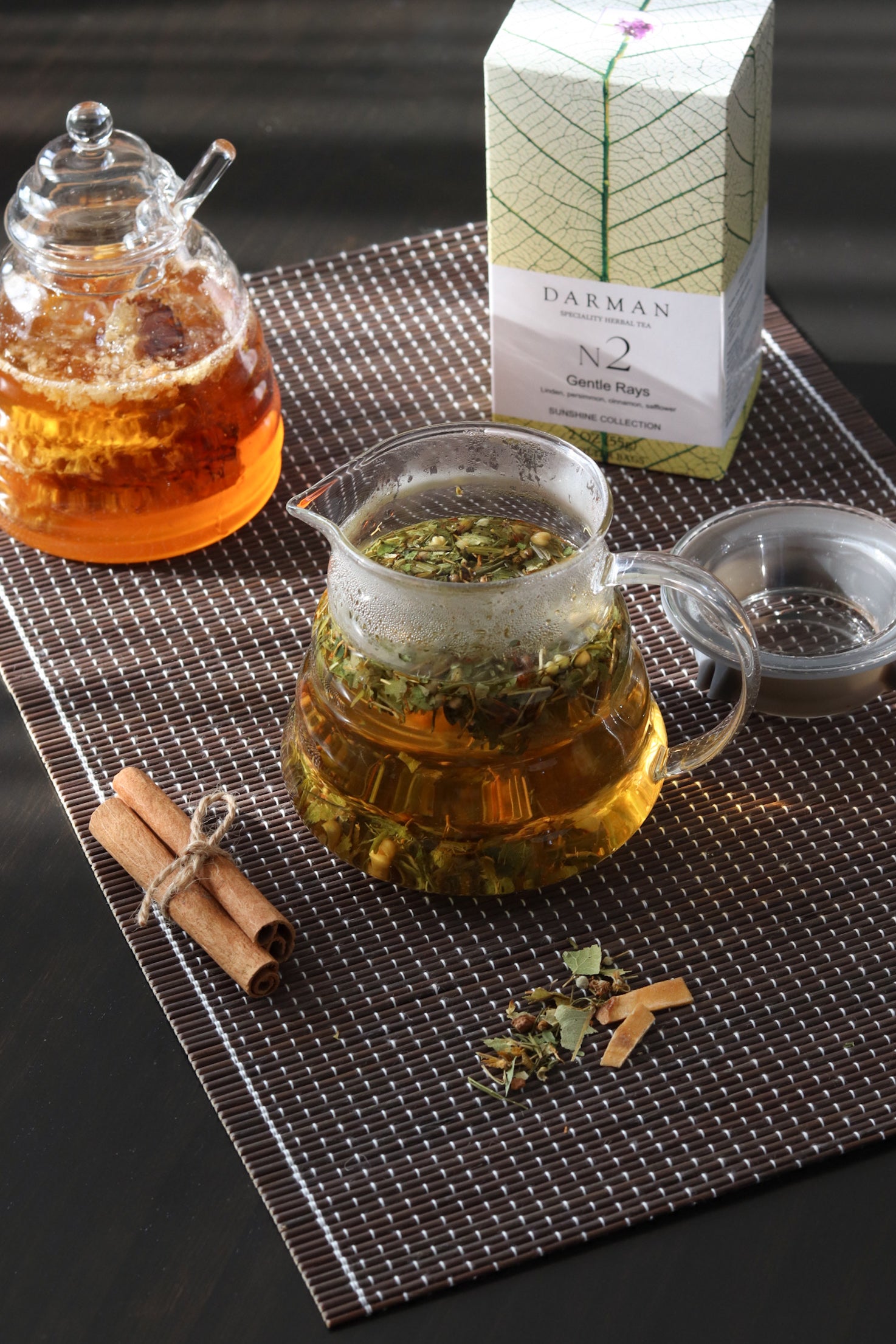 Darman Gentle Rays No.2 tea served in glass pot with box and cinnamon on placemat