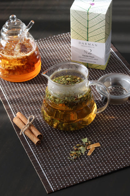 Darman Gentle Rays No.2 tea served in glass pot with box and cinnamon on placemat