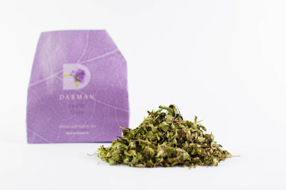 Thyme organic tea from Darman with dried herbs displayed in front of package on white background